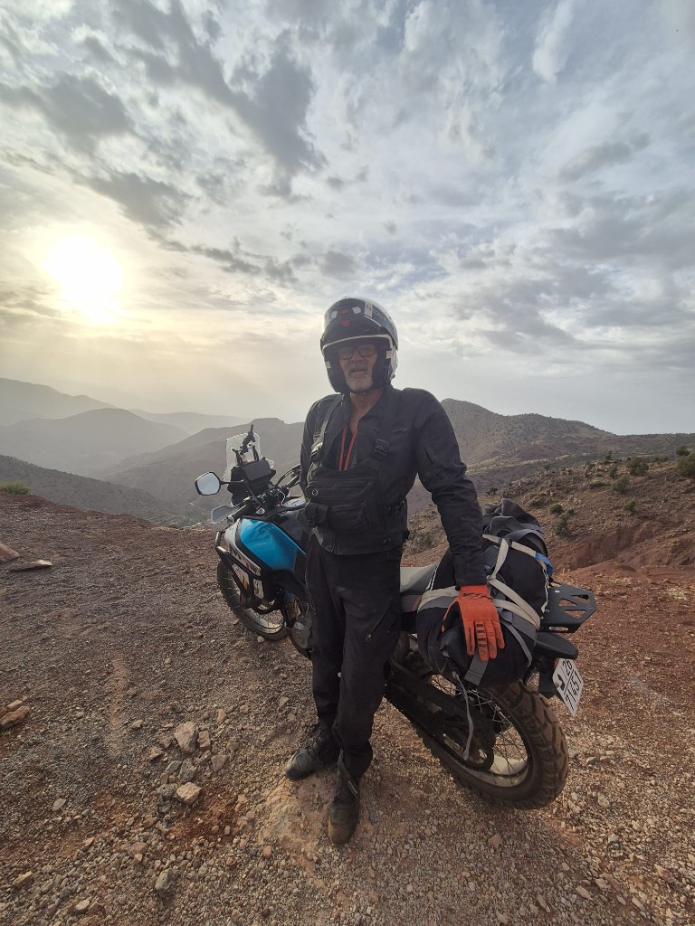 Motard dans un virage en épingle — cols escarpés du Haut Atlas
