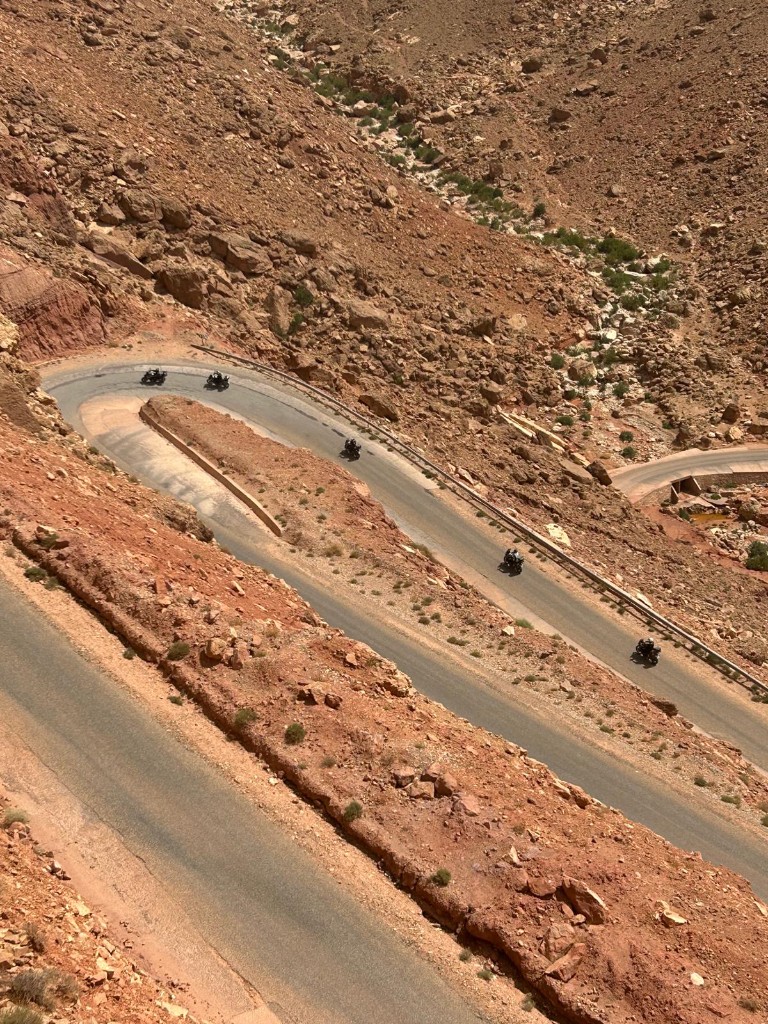 Groupe de motos sur une route en lacets — vue aérienne dans l'Atlas