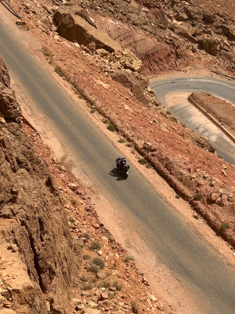 Motard sur une crête de l'Atlas — paysage grandiose au Maroc
