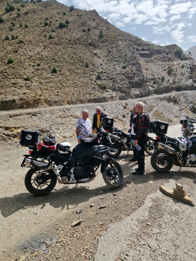 Pause groupe au pied d'une pente rocheuse — convivialité moto
