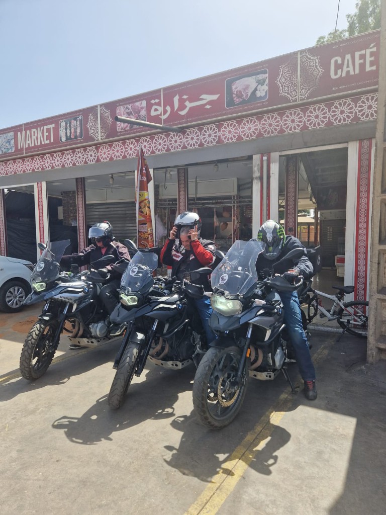 Arrêt café & marché — trois motos BMW devant l'échoppe